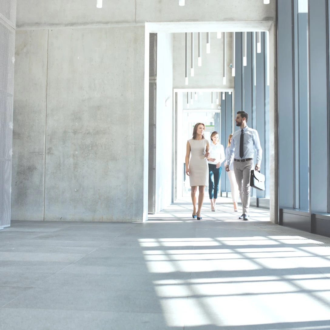 Personen laufen durch einen Innenhof in einem Gebäude